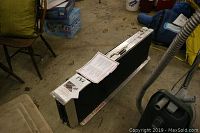 Folded portable ramp with labels and tags visible, showing compactness and foldable metal frame.