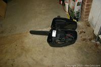 Full view of the Craftsman chainsaw inside its open black carrying case on concrete floor.