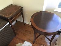 Circular wooden table shows the overall design with a two-tone wood top and curved legs.