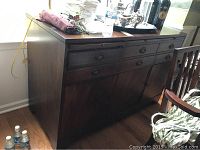 Full view of the dark wood Sligh buffet showing top, side, drawers and cabinet doors. Some scratches and marks visible on top and side.