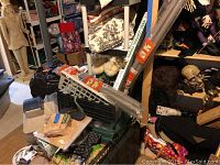 Overview of various pet and garden supplies stacked together including dog feeder, dog bowls, pipes, and fabric rolls.