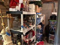 Four plastic shelving units holding various household and storage items in a basement environment.