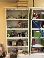 Full view of shelving unit containing various figurines, collectibles, CDs, ceramic items, boxes, and wooden Noah's Ark music box on top shelf.
