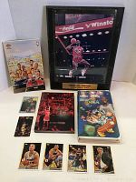 Photo showing Michael Jordan framed autograph plaque, NBA Ultimate Jordan DVD set, Space Jam VHS, and basketball cards.