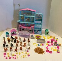 Full view of the vintage Barbie pet shop playset with numerous toy animal figurines and a variety of accessories arranged in front