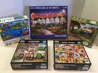 Lot of five 1000-piece jigsaw puzzle boxes with visible titles and artwork including Painted Ladies of San Francisco, Ice Cream Truck, Sweet Treats, Tropical Paradise II, and Flying Scotsman.