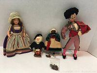 All four dolls in a single photo showing scale and condition, including additional small bag of accessories