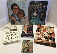 Front view showing all six items in the lot: two hardcover books, two booklets, one soft cover book, and one postcard with images of Prince Charles and related royal themes.