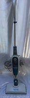Full view of the upright Black and Decker steam mop with long handle and cloth cleaning pad on base.