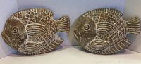 Two ceramic fish wall hanging decorations placed side by side, showing size and surface texture.