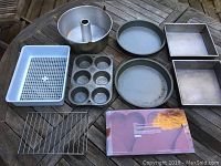 Overview of the entire lot showing the assortment of pans and racks on a wooden surface