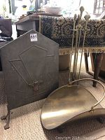Photo of fireplace screen, brass log holder, and fire tool set