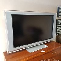 Front view of the 46 inch Sony TV with silver frame and stand.