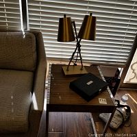 Photo showing wood side table next to couch with lamp and poker set on top