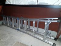 Full view of the ladder in retracted position leaning against a wall, showing length and construction.