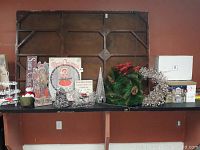 Photo showing assortment of Christmas decorations including wreaths, cupcake stand, decorative sleigh, and wooden plaques.