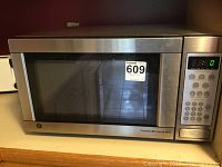 Front view of the GE microwave showing the stainless steel door with viewing window and control panel.