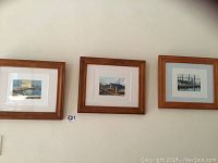 Three matching wood framed watercolours hanging on wall with boating themes.