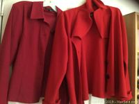 Two red vintage jackets hanging, showing collar and shoulder details.