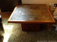 Flagstone top coffee table viewed from above showing tiled surface and wooden frame.