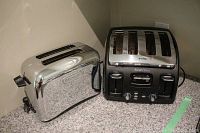 DeLonghi 2-slice and T-fal 4-slice toasters shown side by side on a kitchen counter with granite countertop and beige wall background