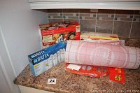 Countertop with Brita water filter box, perogy maker box, and large plastic pie board
