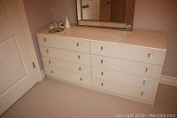 Full front view of the white 8 drawer dresser with metal handles, shows shape and proportion.