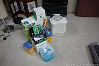 Lot contents set on floor with all retail boxes visible including Homedics foot spa and Hunter humidifier