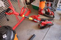 Photo showing Homelite 2-speed electric leaf blower and cutting edge curb runner on concrete floor near red goal net.