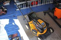 Front-angle view of mower on concrete floor, steel deck and front wheels visible