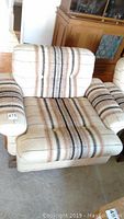 Front view of upholstered chair showing seat cushion and armrests