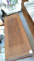 Full view of the rectangular wood coffee table showing the top surface and part of seating furniture around it.