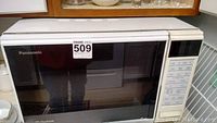 Front closed microwave Panasonic with control panel and door window.