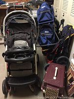 Front view of Mountain Equipment child carrier backpack, two strollers, and pet carrier showing overall condition and colors.