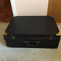 Closed black leatherette case with metal corner guards