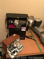 Polaroid 380 camera, Cornice S 25 movie camera in case, Spotmatic photo analyzer box, cables visible on wooden surface