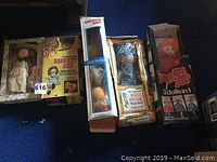 All dolls and walking bird toy in original packaging and loose dolls in box on blue carpet