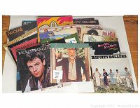 Collection of vinyl record LP albums fanned on a white surface showing a mixture of artist album covers including Rick Springfield, Ray Charles, Bay City Rollers.