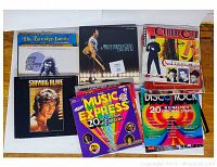 Top view of several vinyl records showing album covers including Bruce Springsteen & The E Street Band, Culture Club, The Partridge Family, Staying Alive, Music Express, and Disco Rock.