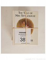 Top view of the stack of Beatrix Potter books bundled with rubber bands, showing 'The Tale of Mrs. Tittlemouse' on top.