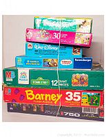 Stack of 7 puzzle boxes, showing variety of brands and piece counts