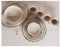 Full set of Noritake China pieces including serving platter, vegetable bowl, cups and plates stacked showing geometric line pattern.