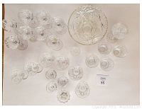 Top-down image showing various crystal glassware pieces spaced out on a table, including glasses, bowls, and small dishes, highlighting cut patterns and overall quantity.
