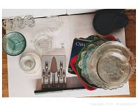 Overview photo showing all items including clear glass dessert plates stacked, green divided serving dish, small clear bowls, frosted bowl, and boxed cutlery set.