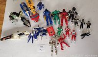 Full view of Power Rangers toys including figures and Mega Zord pieces arranged on floor