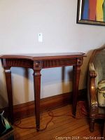Front view of wooden hall table showing carved legs and apron with rosettes.