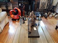 Wide view showing arrangement of six sculptures including a large wood sculpture and five metal sculptures of various human forms and abstract shapes.
