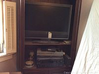 Full view of entertainment unit holding the TV, VHS player, and audio receiver.