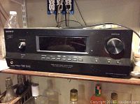 Sony audio/video control center receiver with buttons, knobs, and display on shelf