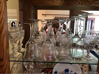 Shelf view showing etched stemware glasses including wine and aperitif glasses, and crystal salt and pepper shakers.